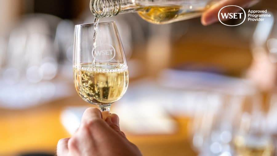 Vinho branco sendo servido numa taça de degustação