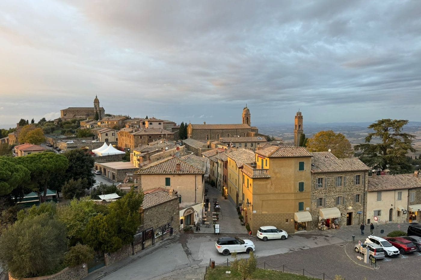 Vista de Montalcino no alto da colina com casario e torres ao entardecer