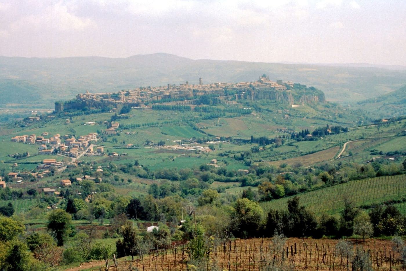Orvieto sobre sua rocha com vinhedos e campos no vale