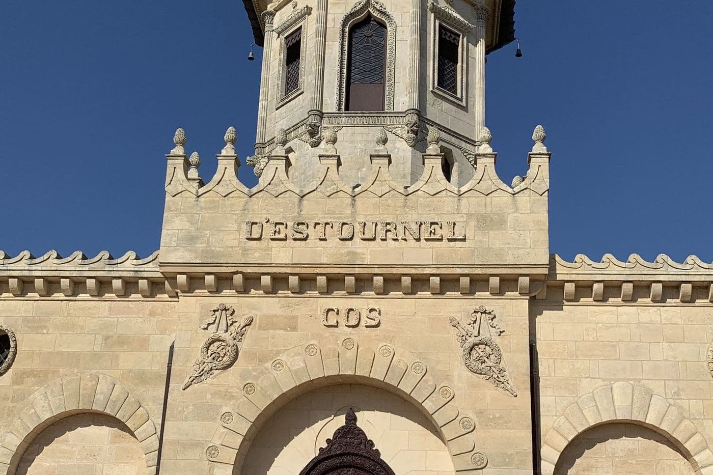 Fachada do Cos d'Estournel com torre e porta em arco